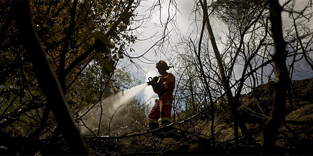 Un bombero trabaja en la extincin del incendio declarao en Mlaga, en Ojn. | Afp