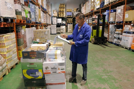 Un voluntario del Banco de Alimentos coteja los datos en el almacén. | Efe