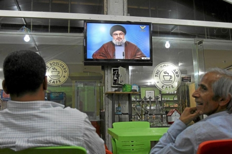 Dos libaneses siguen un discurso anterior de Nasral por televisin.