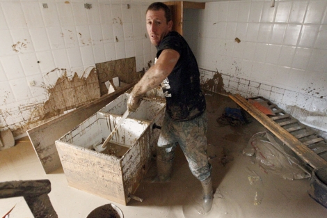 Un hombre limpia el interior de su vivienda en Villanueva del Rosario. | Efe