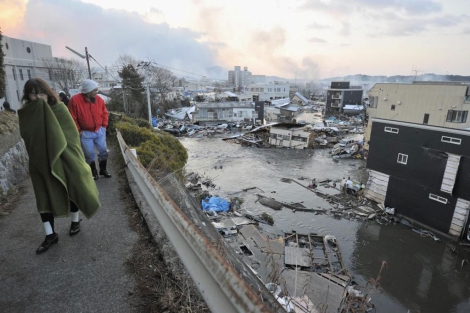 Vecinos miran los edificios destruidos por el 'tsunami' de 2011 en Ksennuma, Japón. | Afp