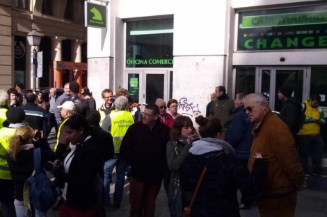Los activistas, entrando hoy en la oficina de Bankia en Gran Vía.