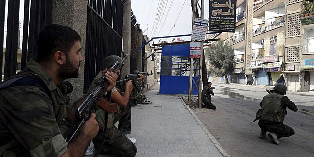 Soldados sirios patrullan una calle de Harasta, al este de Damasco. | Efe