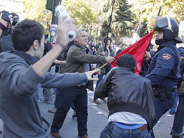 Un piquete protesta frente a un agente antidisturbios. | J. Aymá | VEA LAS MEJORES IMÁGENES