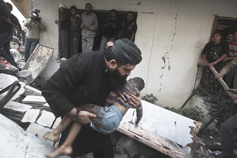 Un hombre transporta el cadáver de uno de los niños de la familia Al-Dallou.| Efe