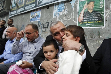 Ismail Haniya, besa a unos nios delante de una foto de Jabari.| Reuters