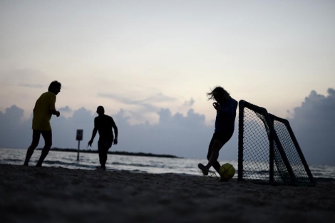 Varios israeles juegan en una playa de Tel Aviv.| Afp