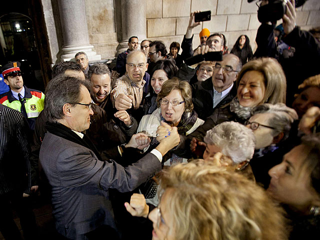 Artur Mas saluda a las personas concentradas en la plaza de Sant Jaume. | Efe