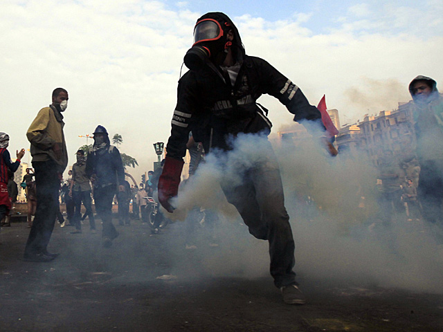 Un manifestante se protege del gas lacrimgeno en la plaza Tahrir. | Reuters