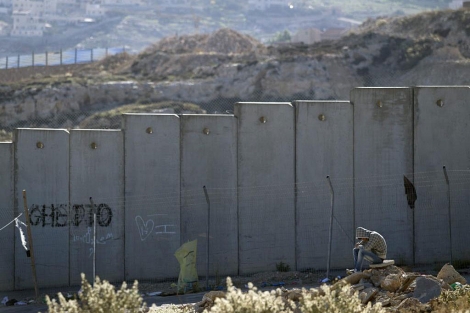 Un palestino sentado junto al muro de separacin israel en Hizme (Cisjordania). | Efe