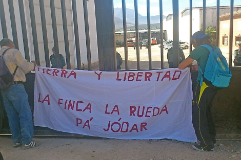 Militantes del SAT colocan una pancarta a las puertas de la finca La Rueda. | M. Cuevas