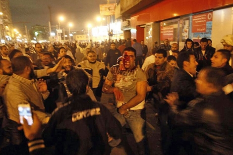 Un opositor a Mursi, herido, rodeador de partidarios del presidente.| Afp MÁS IMÁGENES