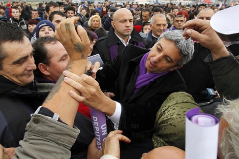 Diaconescu firma en el brazo de un seguidor, en un acto de campaa.| Reuters