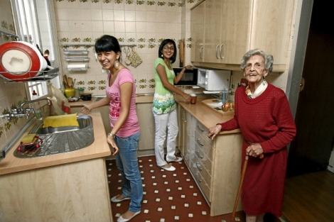 Una anciana en la cocina de su casa junto a dos jvenes. | B. Rivas