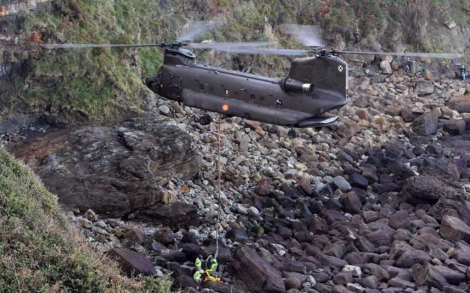 El helicóptero recogiendo la roca con el fósil. | Efe
