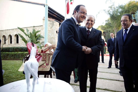 El presidente Hollande (izda.) saluda a su homlogo argelino en Argel. | Afp