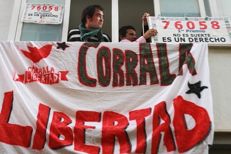 Los 'ocupas' colocan un cartel en un balcn.| C. Mrquez