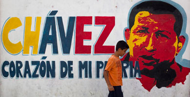 Un nio camina por delante de un mural de Chvez. | Reuters