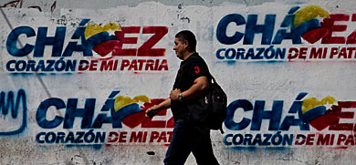 Un transente, delante de un grafiti en favor de Chvez, en Caracas. | Efe