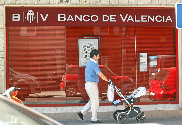 Un hombre pasea frente a una oficina del Banco de Valencia. | Reuters