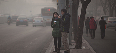 Dos jvenes en una calle de Pekn afectada por la polucin. | Afp
