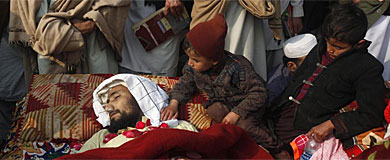 Un nio, junto a uno de los 15 cadveres, en Peshawar.| Reuters