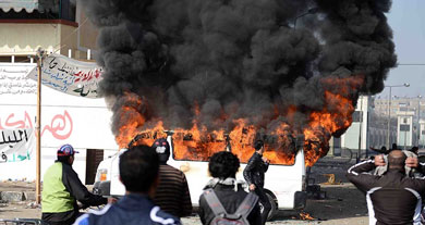 Un minibs quemado a las afueras de Port Said. | Afp VEA MS IMGENES.
