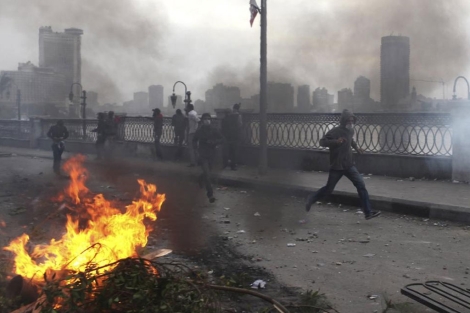 Opositores a Mursi corren entre gas lacrimgeno junto a la plaza Tahrir . | Reuters