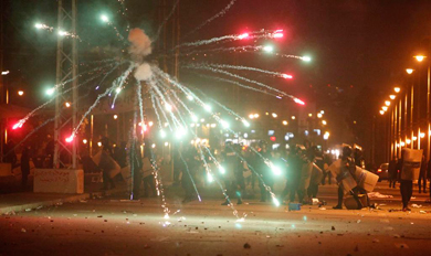 Los manifestantes lanzan fuegos artificiales a los policas en El Cairo.