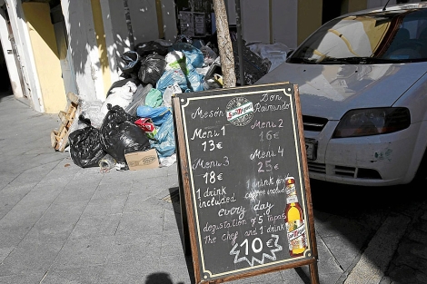 Men de un restaurante delante de un montn de basura. | J. Morn