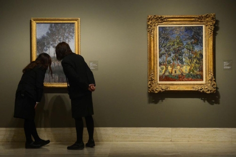 Dos mujeres observan 'lamos al borde del Epte, vista de la marisma', de Monet. | Afp