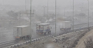 Camiones circulan por la A-3 en plena nevada. | V. Bosch