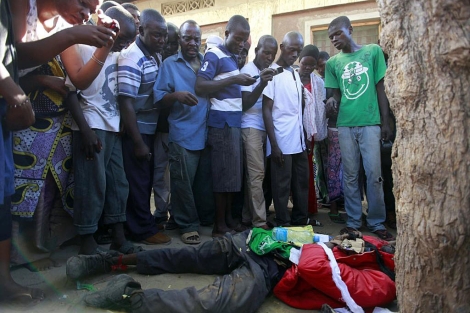 Curiosos contemplan el cadver de un asesinado en Mombasa. | Reuters