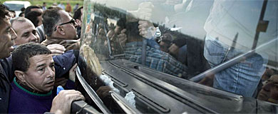 Trabajadores palestinos cogen el autobs en Kalkilia.| Afp