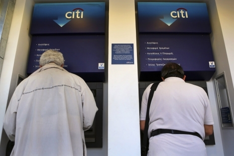 Dos hombres sacan dinero de un cajero en Atenas. | Reuters
