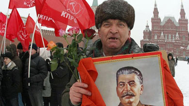 Un hombre del partido comunista, con una foto de Stalin. Archivo.| Afp