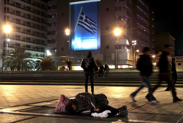 Pobreza frente a un cartel que pone "Grecia, te quiero". | Reuters
