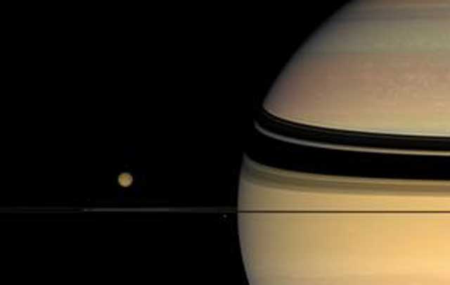 La luna Titn, orbitando el planeta Saturno. | NASA