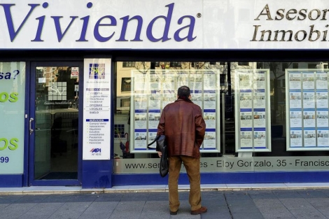 Un hombre mira anuncios de viviendas en venta de una inmobiliaria en Madrid. | Bernardo Daz