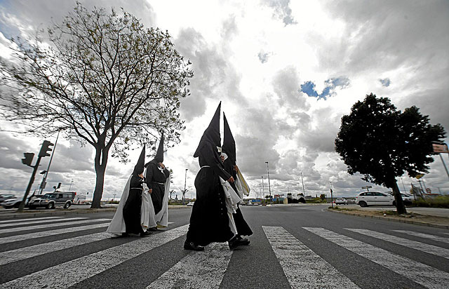 Nazarenos de la hermandad del Cachorro se dirigen a su templo, el Viernes Santo de 2012. | Diego L.