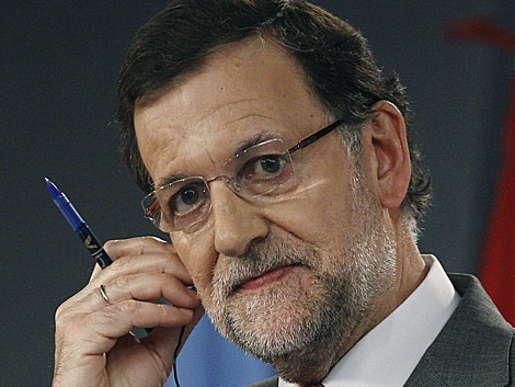 Rajoy se ajusta el auricular de la traduccin simultnea en la rueda de prensa. | Ballesteros / Efe