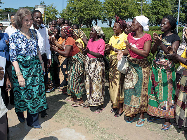 La Reina pasa ante un grupo de mujeres que le cantan durante su visita en Manhia. | ngel Daz / Efe