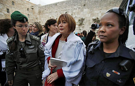 Una de las mujeres, con el manto masculino, ante el Muro.| Afp