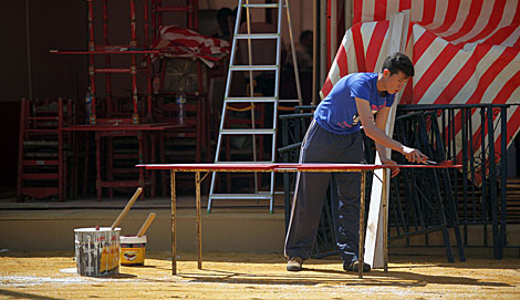 Un operario pinta las maderas de una caseta en el Real de la Feria. | Jess Morn