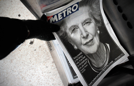 Una mujer coge un peridico gratuito, con la portada de Margaret Thatcher por su muerte. | Afp