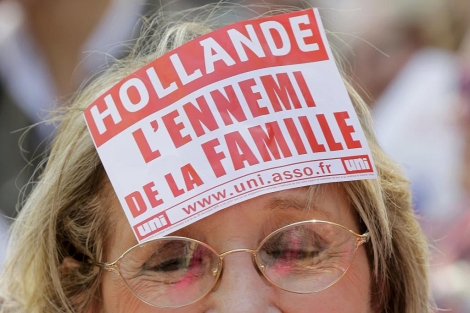 Una mujer luce un cartel que califica a Hollande de "enemigo de la familia". | Reuters