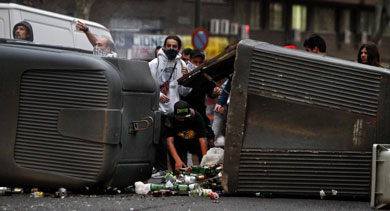 Manifestantes cogen botellas de los contenedores volcados. | Alberto Di Lolli