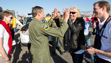 Richard Branson (con gafas de sol) saluda a uno de los pilotos tras el aterrizaje. | V. Galactic.