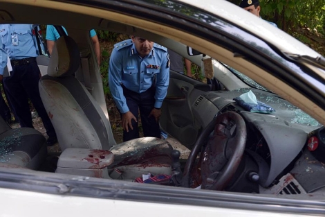 Un policía observa el estado en que quedó el coche de Zulfiqar. | Afp