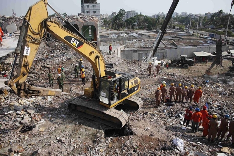 Una excavadora busca entre los restos del edificio derrumbado en Bangladesh. | Reuters
